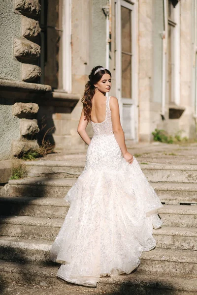 Modelo de noiva jovem atraente em belo vestido de noiva andando no parque — Fotografia de Stock