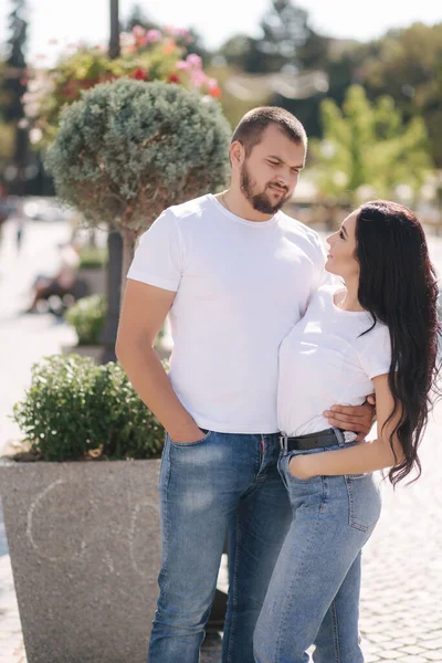 穿着斜纹棉布和白色T恤衫的时髦夫妇站在市中心。夏末概念 — 图库照片