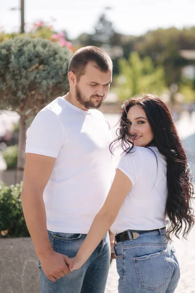 Stilvolles Paar in Jeans und weißen T-Shirts steht mitten in der Stadt. Spätsommerliches Konzept — Stockfoto