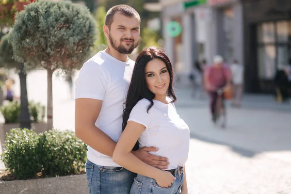 Pareja con estilo en mezclilla y camisetas blancas en el centro de la ciudad. Concepto de finales del verano —  Fotos de Stock