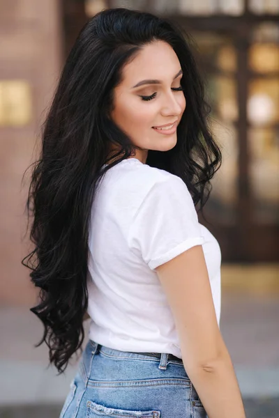 Porträtt av vacker ung brunett kvinna i vit t-shirt. Vacker makeup — Stockfoto