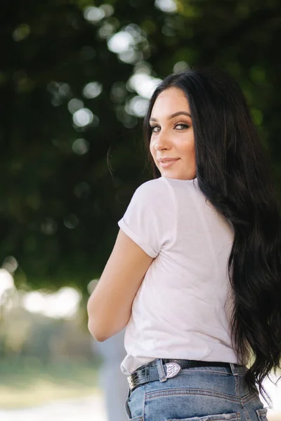 Portret van een mooie jonge brunette in een wit t-shirt. Mooie make-up — Stockfoto