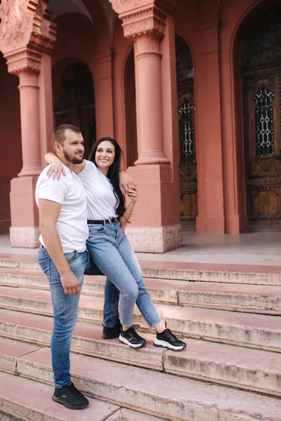 Zwei Geliebte spazieren durch die Stadt. Schönes Paar in Jeans und weißem T-Shirt hat Spaß — Stockfoto