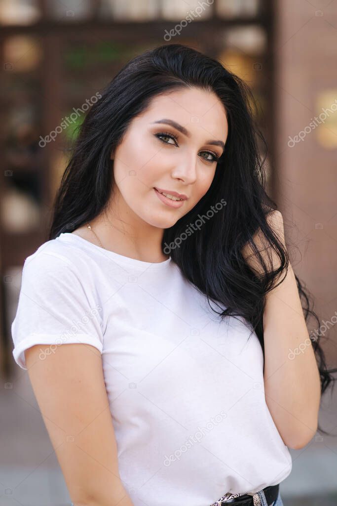 Portrait of beautiful young brunette woman in white t-shirt. Beautiful makeup