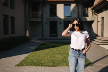 Güzel esmer model fotoğrafçıya açık havada poz veriyor.