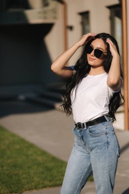 Güzel esmer model fotoğrafçıya açık havada poz veriyor.