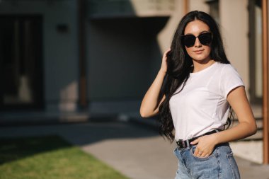 Güzel esmer model fotoğrafçıya açık havada poz veriyor.