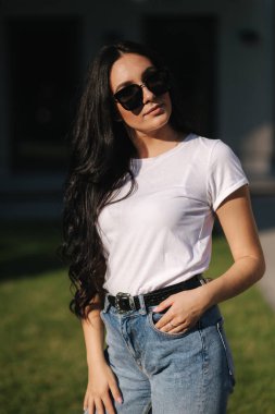 Güzel esmer model fotoğrafçıya açık havada poz veriyor.