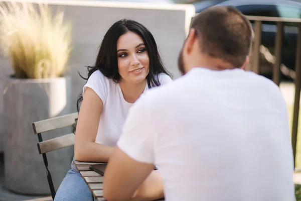 屋外のカフェに座っている男性と女性のカップルとお互いを見てください。幸せな愛する人たち — ストック写真