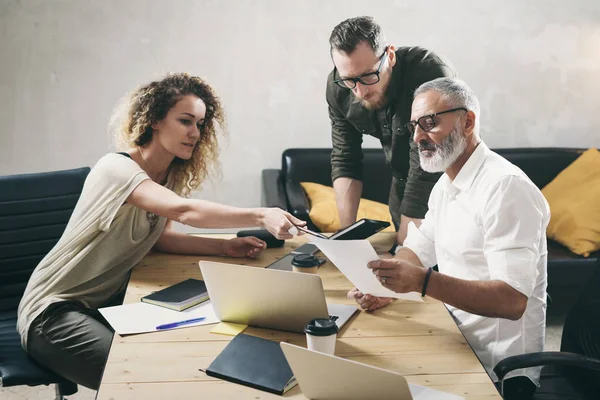 Junges Team von Mitarbeitern, die großartige Arbeitsgespräche in modernen Büros führen. Bärtiger Mann im Gespräch mit Marketingdirektor und Assistenzmanager. Geschäftsleute treffen Konzept. — Stockfoto