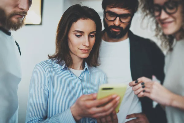 Collega's vergadering bedrijfsconcept. Jonge vrouwen die mobiele smartphone hand en weergave van informatie aan haar collega's. Bijgesneden. — Stockfoto