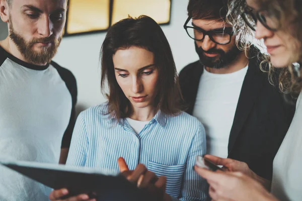 Çalışma anlar fotoğraf. Grup Genç iş elektronik kullanarak touch pad birlikte modern ofis çatı katında