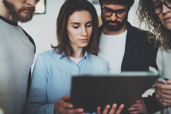 Samen teamfoto naaiatelier. Groep van jonge collega's met behulp van elektronische touchpad in moderne kantoor loft — Stockfoto