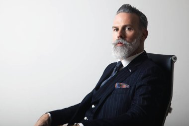 Portre pozitif boş gri arka plan üzerinde şık takım elbise orta yaşlı beyefendi sakallı. Yapıştırma alanı kopyalayın. Stüdyo vurdu