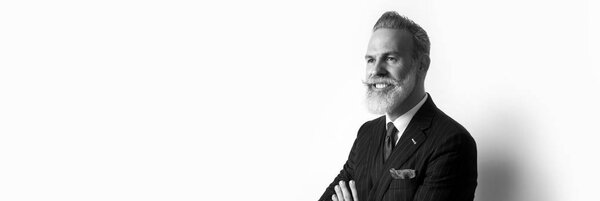 Portrait of bearded attractive gentleman wearing trendy suit over empty white background. Copy Paste text space. Wide. Black and White