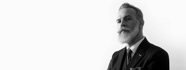 Portrait of bearded handsome gentleman wearing trendy suit over empty white background. Copy Paste text space. Wide. Black and White