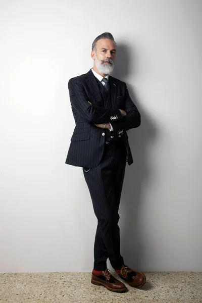 Portrait of confident bearded middle aged gentleman wearing trendy suit standing over empty white background. Studio shot. Vertical — Stock Photo, Image