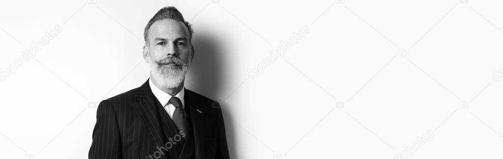 Portrait of bearded attractive businessman wearing trendy suit over empty white background. Copy Paste text space. Wide. Black and White