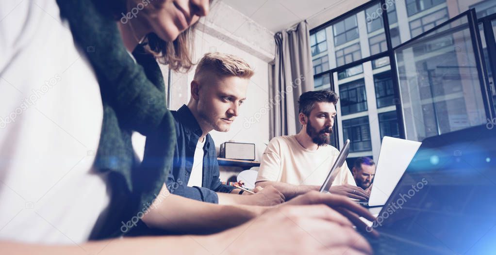 Business professionals at working moments. Group of young confident coworking people analyzing data using computer while spending time in the office. Wide.