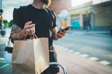 Kurye Bisiklet teslimat yemek servisi evde. Sakallı adam kurye teslimat adresi şehirde bulmak için cep telefonu bir harita app kullanma