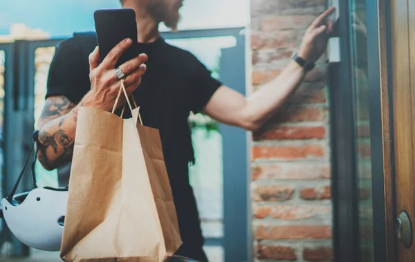 Courier levering foodservice thuis. Bebaarde Man courier geleverd de volgorde geen naam tas met voedsel — Stockfoto