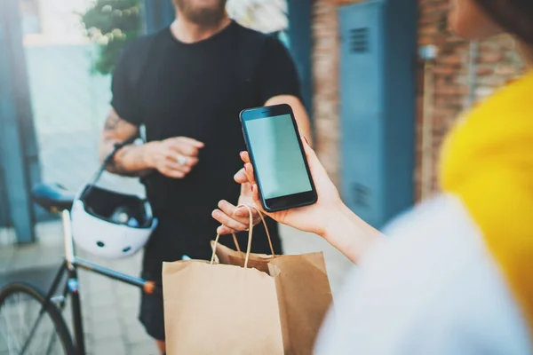 Courier levering foodservice thuis. Vrouw controleren de geleverde bestellen geen naam tas met voedsel met mobiele telefoon. — Stockfoto
