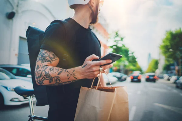 Courier levering foodservice thuis. Courier van de mens met behulp van een kaart app op mobiele telefoon te vinden van het adres van de geadresseerde in de stad — Stockfoto