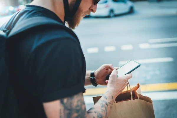 Snelle levering voedsel koeriersdienst thuis. Courier van de mens met behulp van een kaart app op mobiele telefoon te vinden van het adres van de geadresseerde in de stad — Stockfoto