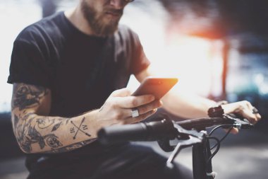 Sakallı dövmeli adam göndermek kısa mesaj için sürme sonra şehirde elektrikli scooter tarafından cep telefonu kullanarak güneş gözlüğü.