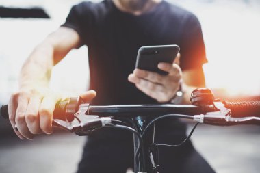 Smartphone elele ve şehrin elektrikli scooter sürme önce maps uygulaması kullanılarak hipster dövmeli adam.