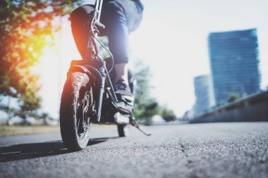 Elektrik kentsel ulaşım. Genç adam tarafından elektrikli scooter binmek kentsel şehri keşfetmek hazır. Geniş. İşaret fişeği