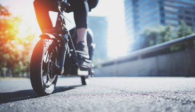 Elektrik kentsel ulaşım. Genç adam tarafından elektrikli scooter binmek kentsel şehri keşfetmek hazır. Geniş. İşaret fişeği