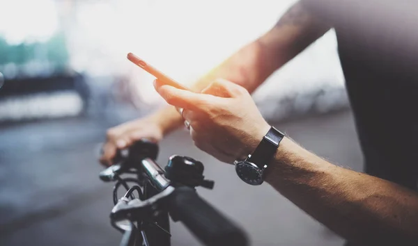 Getatoeëerd hipster man in hand in hand voor smartphone en kaarten app alvorens te rijden via elektrische scooter in de stad. Innovatief vervoer. — Stockfoto