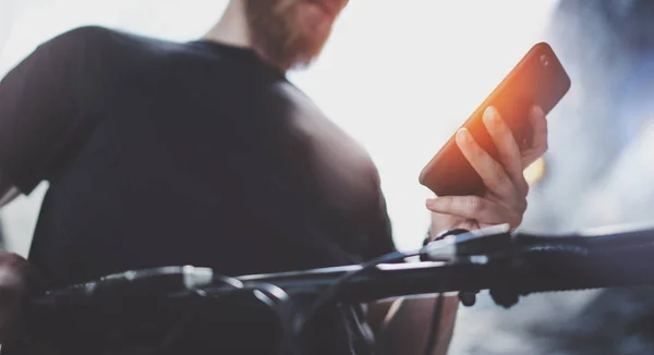 Tetovált izmos férfi mobiltelefon tartja a kezében, és segítségével Térkép app elkészítése kört út útvonalon. Fedezze fel városi elektromos robogó — Stock Fotó