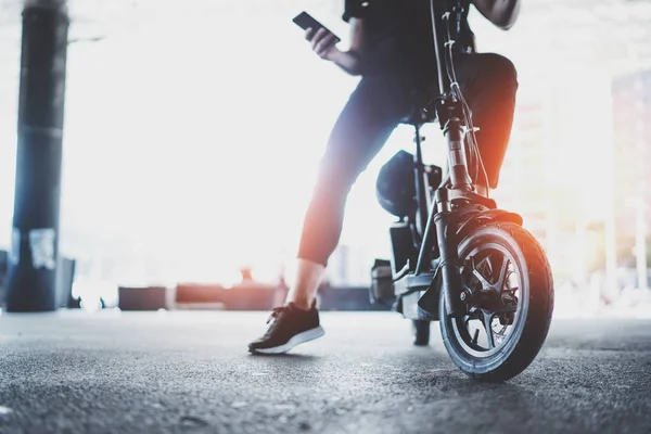 電気都市交通。都市の中心部に彼の電動スクーター自転車に乗る準備ができている若い男。革新的な輸送. — ストック写真