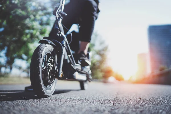 Elektrische stedelijk vervoer. Jonge man klaar om te rijden zijn fiets van de elektrische scooter in het centrum van een stad. Innovatief vervoer. — Stockfoto