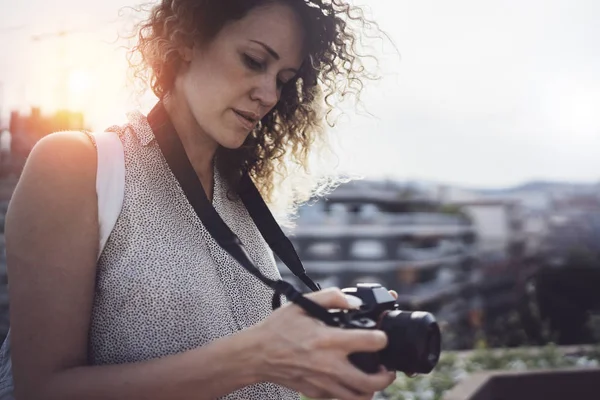 Portret uśmiechający się ładną dziewczynę w strój biorąc zdjęcie retro aparatu na tle zachodu słońca z bliska — Zdjęcie stockowe
