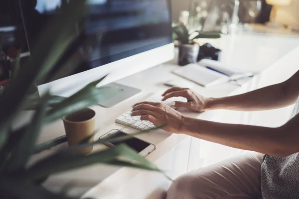 Manos femeninas escribiendo en el teclado de la computadora de escritorio en el lugar de trabajo moderno en la oficina de coworking. . — Foto de Stock