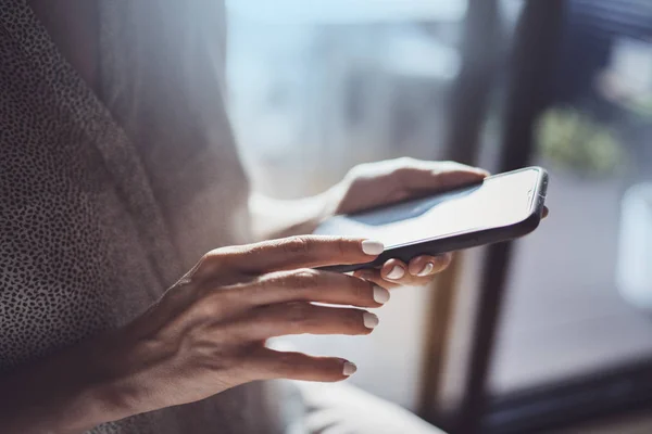 Kvinnliga händer använder mobiltelefon på solig dag i arbetsplatsen. Horisontella. Suddig bakgrund. — Stockfoto