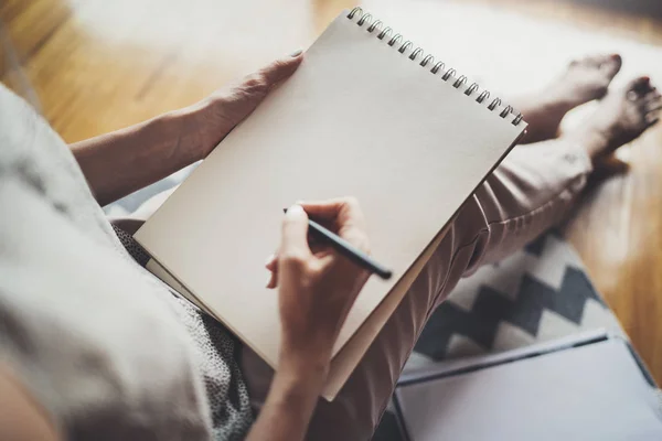 Trabajando en casa concepto. Joven mujer de negocios escribiendo y tomando notas mientras se relaja sentado en silla de confort en casa. Preparación de planes para la próxima semana — Foto de Stock