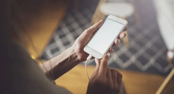 Vrouwelijke handen met behulp van mobiele telefoon op een zonnige dag in de werkplek. Horizontaal. Onscherpe achtergrond. — Stockfoto