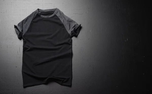 空のヴィンテージ t シャツ黒の木製テーブルの背景にあります。レトロな古典的な服を流行に敏感なアメリカのフロント ビュー。コピー貼り付けスペース — ストック写真