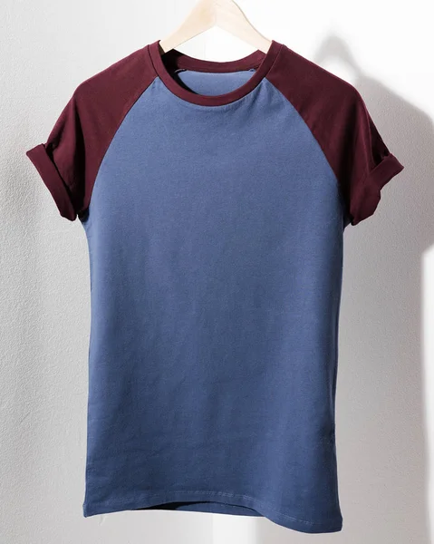 Čelní pohled americké bokovky retro klasické tričko oblečení. Prázdná šablona vintage tričko visí na závěs na bílém pozadí. Closeup. — Stock fotografie