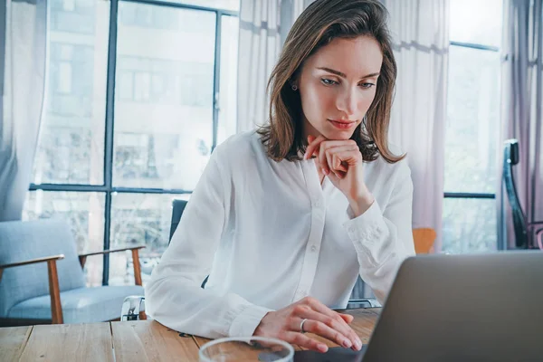 Pensive przedsiębiorca kobieta za pomocą mobilnego laptopa do szuka nowego rozwiązania biznesowego podczas procesu pracy w biurze. Niewyraźne tło. — Zdjęcie stockowe