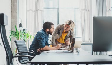 Ofis konseptinde beyin fırtınası sürecinin yakından görünümü. Genç iş arkadaşları birlikte güneşli ofis stüdyosu çalışmak.