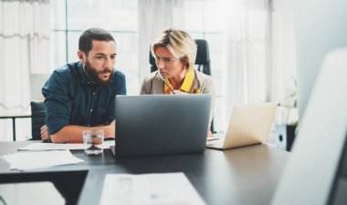 İki iş arkadaşı çalışıyor. Modern ofiste meslektaşı ile birlikte çalışan genç bir kadın. Takım çalışması konsepti.