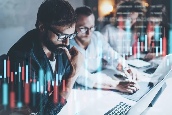 Business team working together at night office.Technical price graph and indicator, red and green candlestick chart and stock trading computer screen background. Double exposure