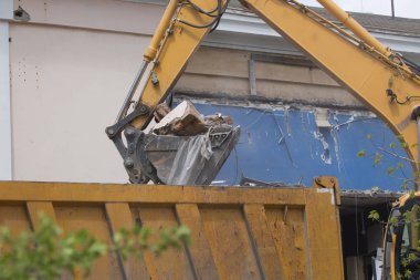 Tekerlekli Ekskavatör inşaat enkaz ve enkaz bir damperli kamyon gövdesinde imha sonra eski bina duvarlarında yükleme yapmak