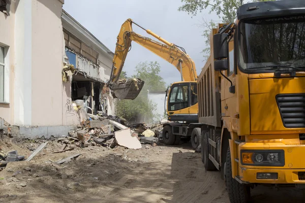 Tekerlekli Ekskavatör inşaat enkaz ve enkaz bir damperli kamyon gövdesinde imha sonra eski bina duvarlarında yükleme yapmak