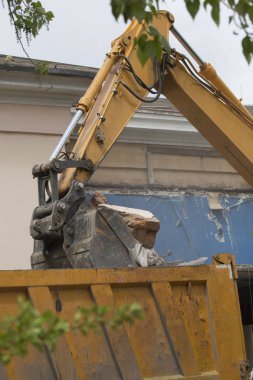 Tekerlekli Ekskavatör inşaat enkaz ve enkaz bir damperli kamyon gövdesinde imha sonra eski bina duvarlarında yükleme yapmak